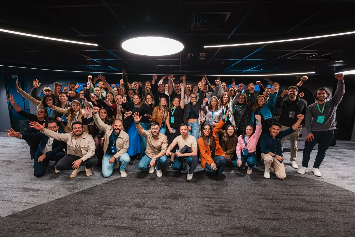 Turma completa de um encontro presencial da Craft comemorando de braços erguidos